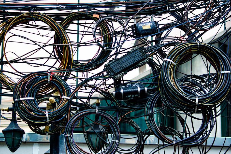 Chaotiškai susukti ir susipynę kabeliai prie elektronikos, kas sukelia trikdžius ir gedimus