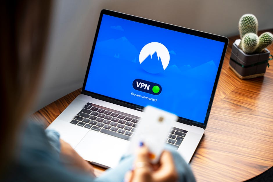 Asmuo prie nešiojamo kompiuterio įjungia saugią prieigą per VPN
